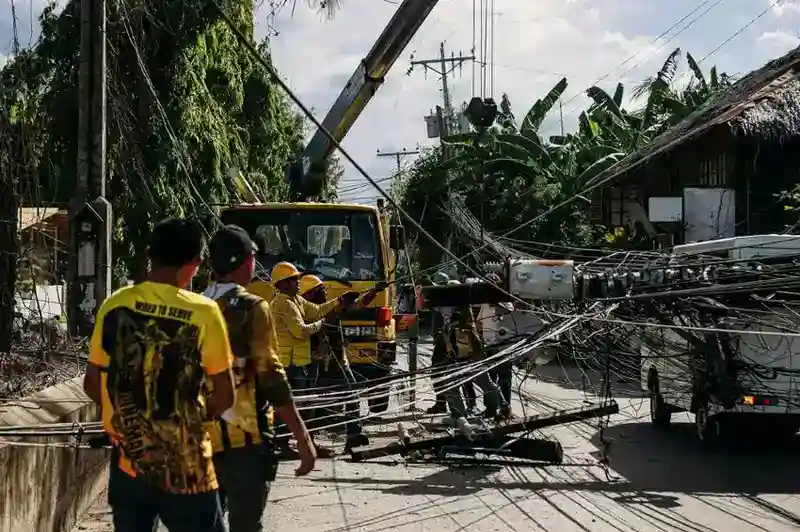 emergency-tree-service-valdosta-ga 1 Utility company technicians operating yellow crane equipment to restore downed electrical infrastructure in residential neighborhood